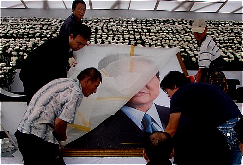 고 김대중 전대통령의 영정사진의 포장지가 걷히고 있다.